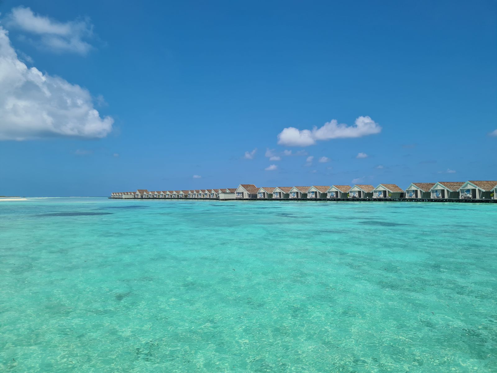 Maldives turquoise lagoon and distant villas