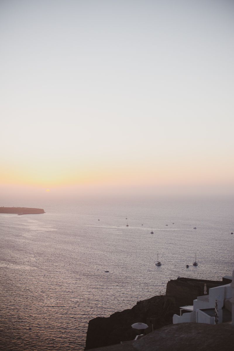 Calm Aegean sunset with boats on the horizon