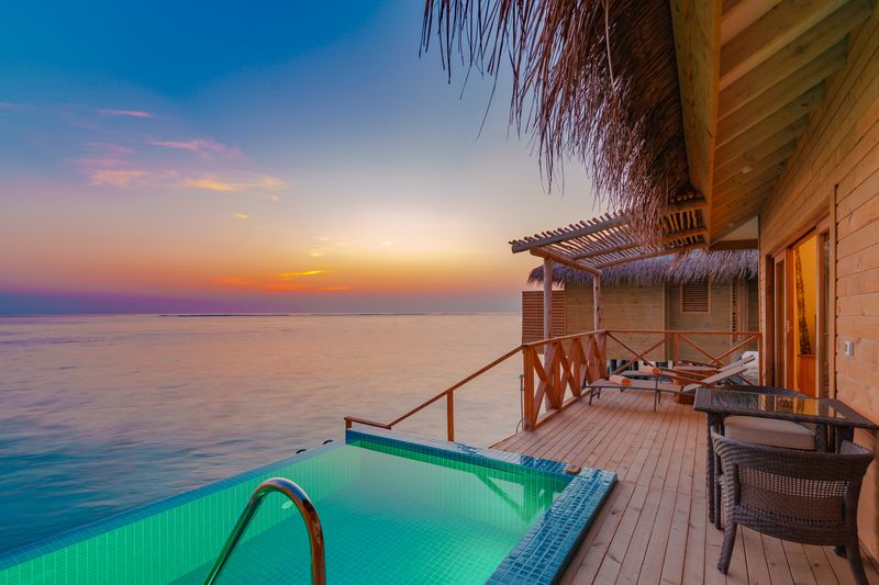 Overwater villa with a private pool at sunset