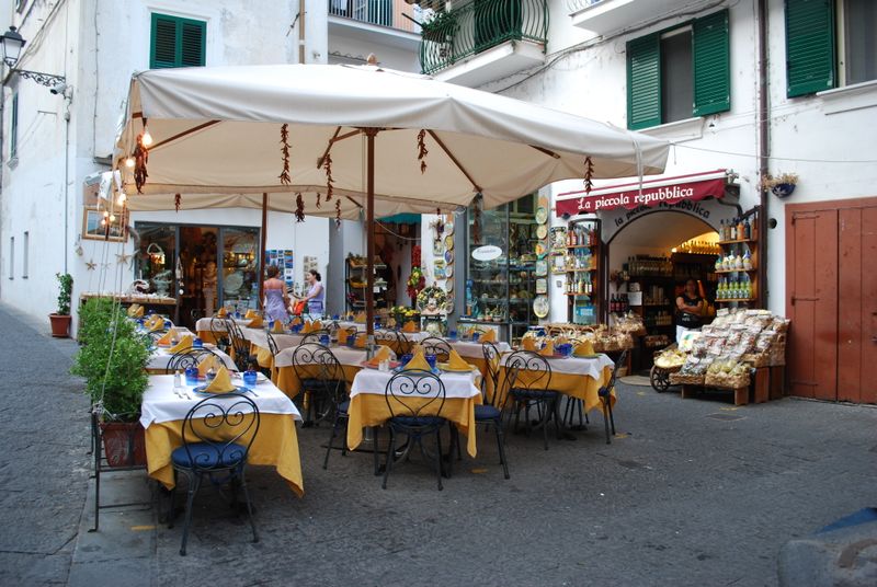 Outdoor café tables under umbrellas in Amalfi